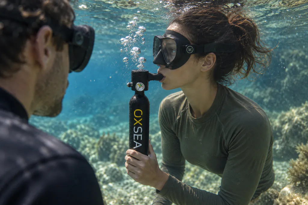 A diver breathes beneath the surface from an OX500.